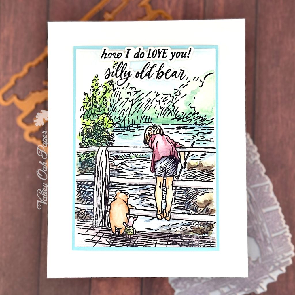 Greeting card featuring an illustration of Winnie the Pooh, Piglet and Christopher Robin on a bridge across a river. 