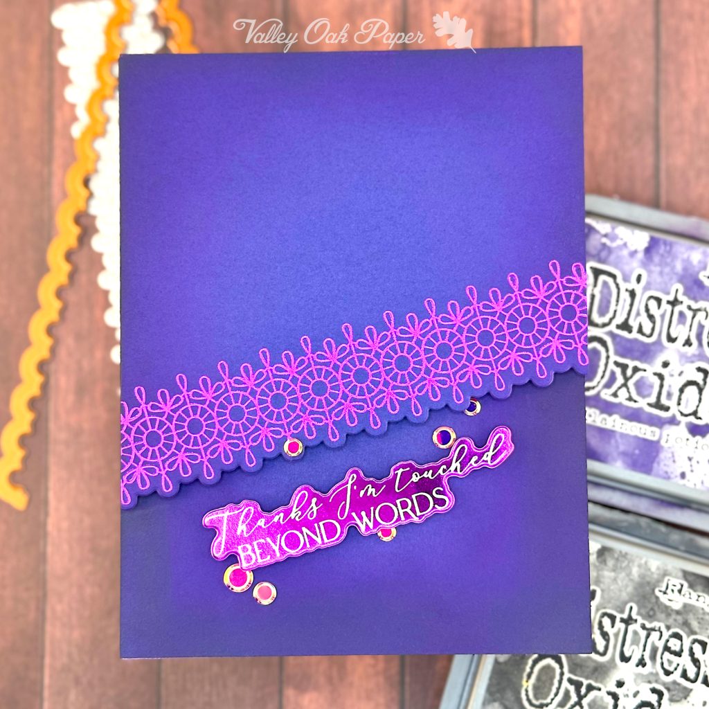 Dark blue greeting card with a purple foiled border diagonally across it. The greeting reads "Thanks, I'm touched beyond words."