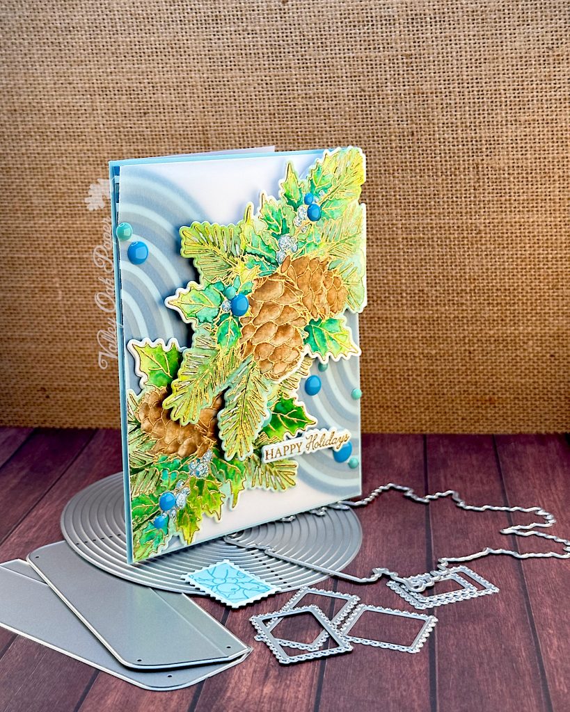 Greeting card featuring two large botanical die cuts on top of two paper-pieced half-ovals. The greeting reads Happy Holidays.