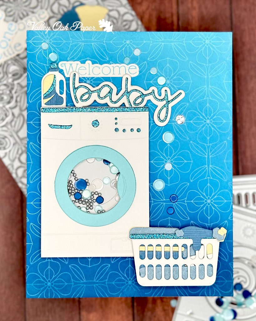 Greeting card using Trinity Stamps Spin Cycle Die Set with a shaker element. The greeting reads "Welcome Baby."