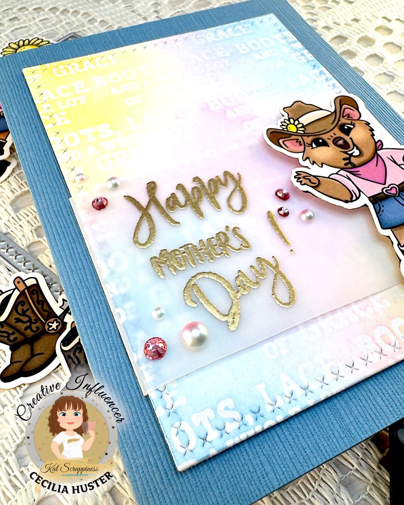 Denim blue greeting card with a background in pastel colors. The focal point is a cowgirl quokka next to the sentiment. The sentiment reads "Happy Mother's Day!"
The card is lying at an angle, so that the greeting is emphasized.