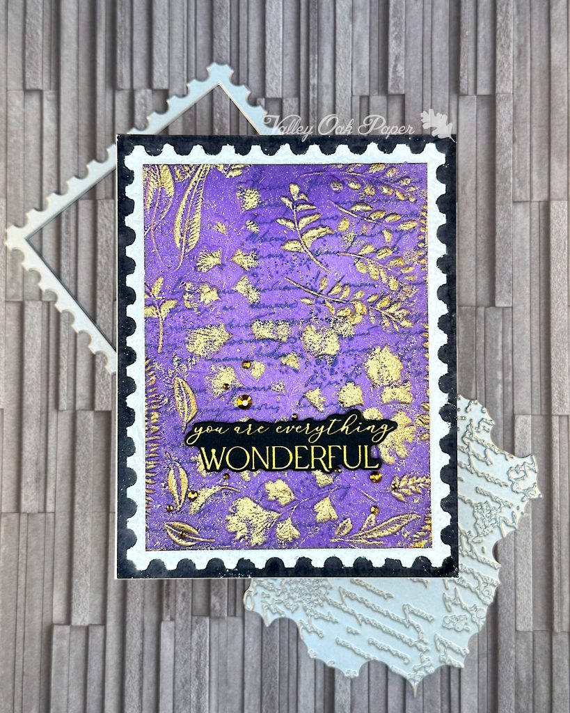 Black greeting card with a purple postage stamp taking up most of the space. The greeting reads "You are everything wonderful." This is on a slate grey background.