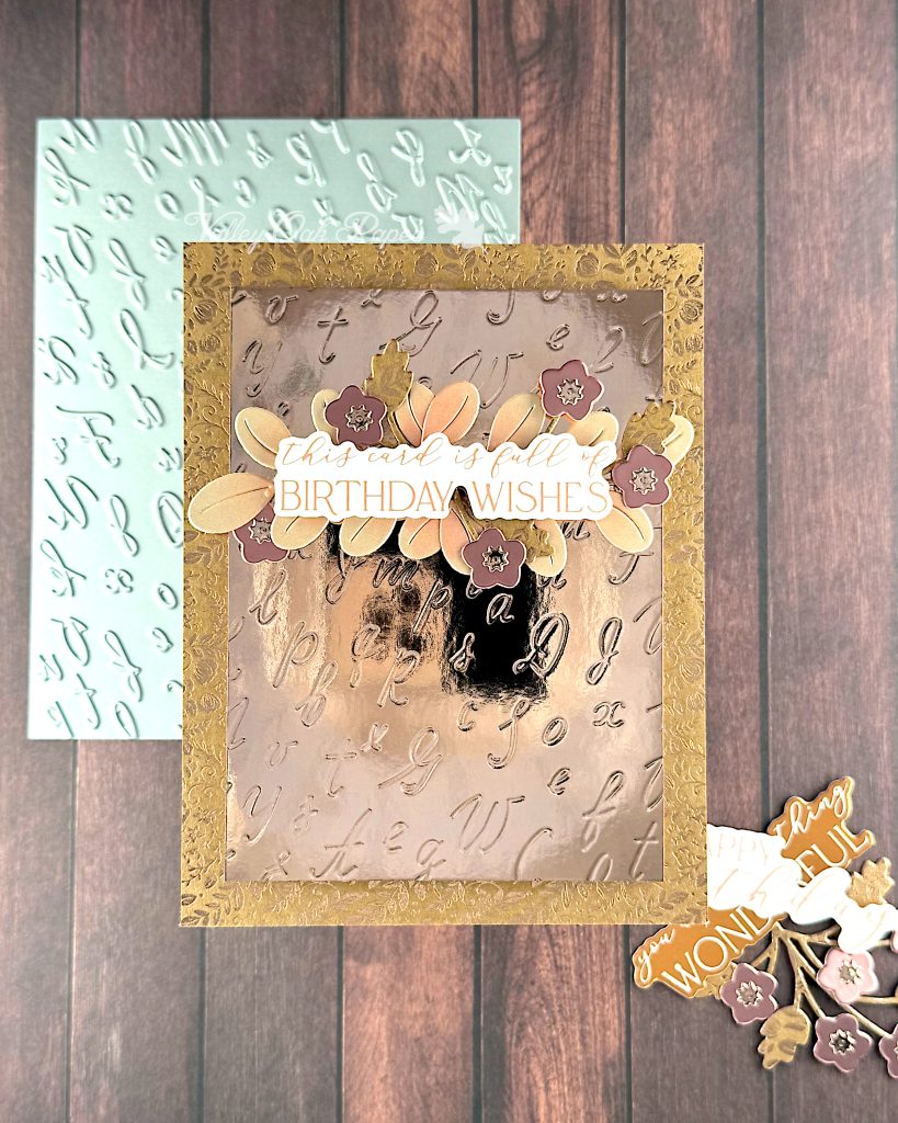A greeting card in rosegold tones. The background is Kraft cardstock with a ditsy pattern in rosegold foil. The main panel is rosegold mirror cardstock with an embossed pattern of cursive letters.
The greeting reads "This card is full of birthday wishes." It's anchored by leaves and flowers in different shades of rosegold.
Under the card lies the pressplate that was used to create the letter pattern and a few die cuts that didn't make it onto the card.