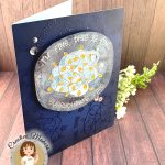 A handmade greeting card with a navy background. The main feature of the card is a watercolor panel showing a tangled light string with lights in amber. The text around the image says "I'm fine. This is fine. Everything's fine." A few silver sequins adorn the card front. The card has been photographed on a rustic wooden background. It's facing right. In the lower left corner is a watermark with the text "Creative Maker for Kat Scrappiness: Cecilia Huster."
